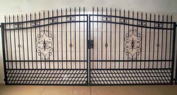 Dwuskrzydłowa, czarna brama ogrodzeniowa z metalowymi prętami i ozdobnymi elementami, widoczna od frontu, na jasnym tle.